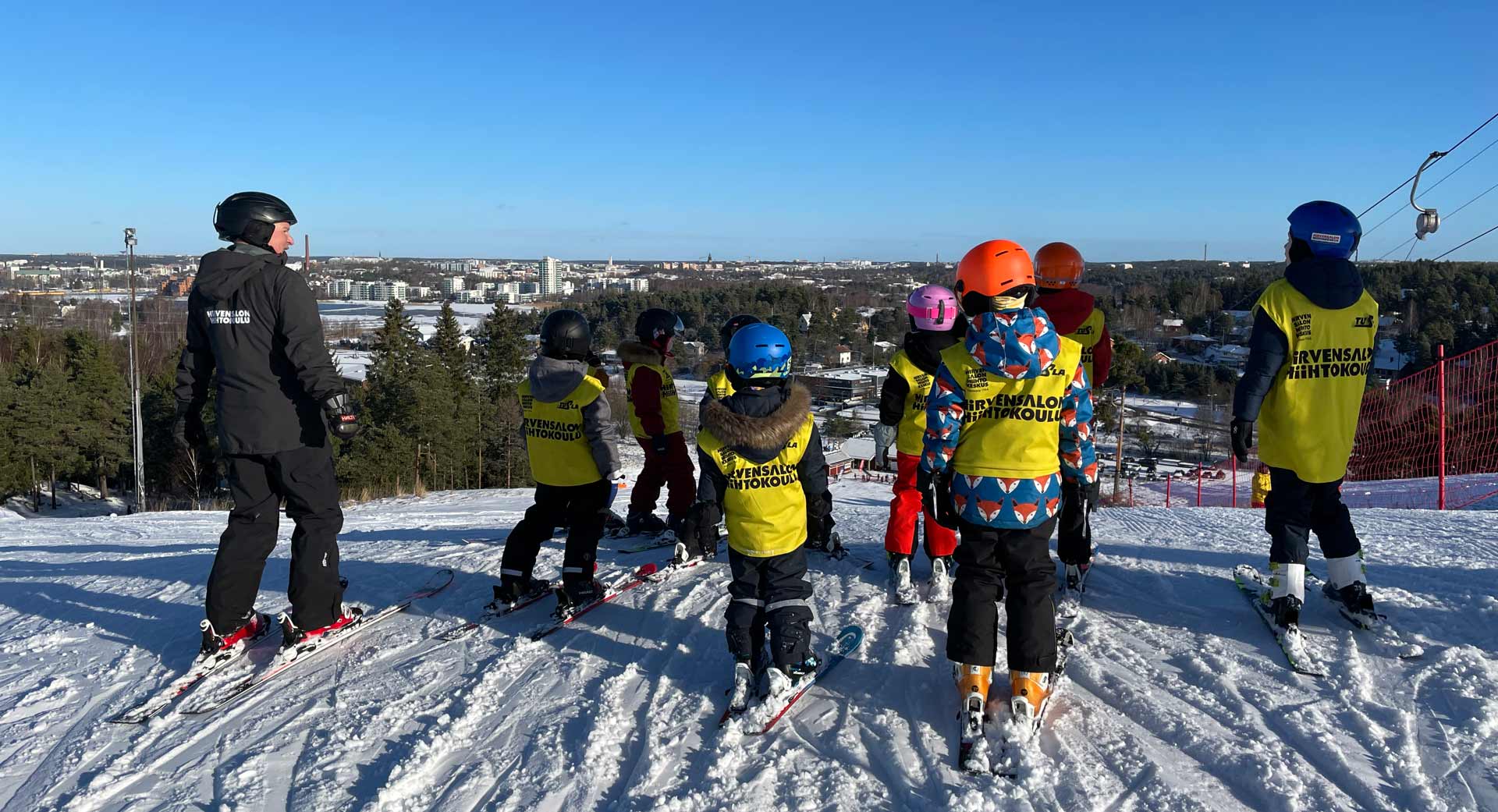 Hiihtokouluryhmä laskettelurinteen päällä